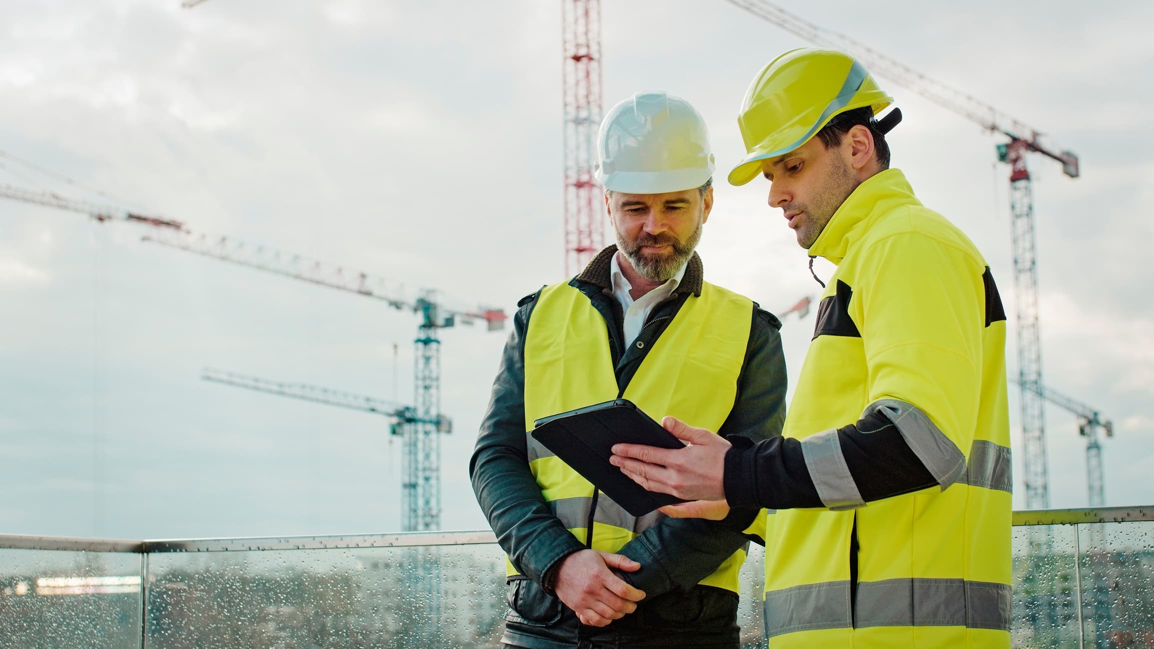 Technician inspecting crane with tablet device
