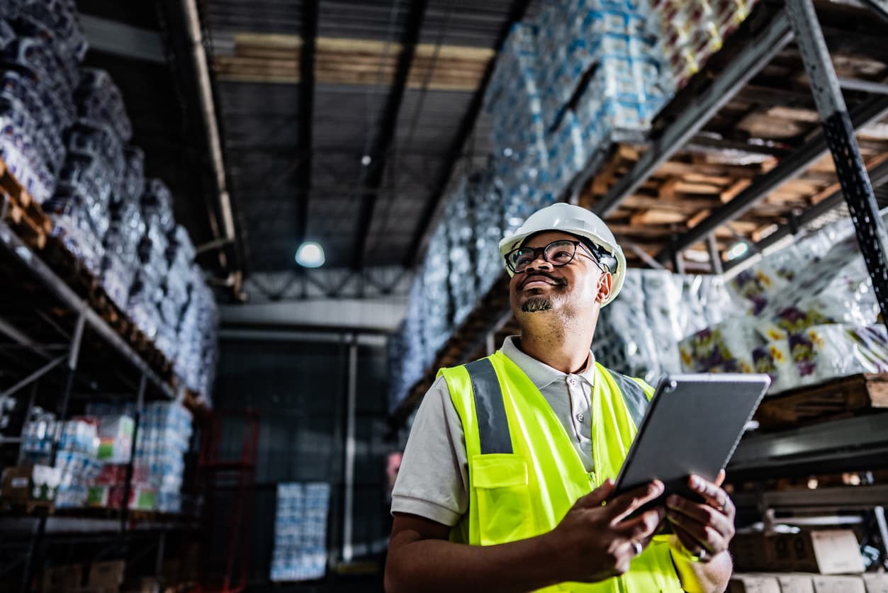Inspector reviewing inspection records on a tablet in a warehouse